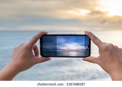 Taking Photos On The Mobile Phone Of Sea View, Taking Photo Vacation Time To The Sea, Hand On Mobile Take Sea Scape View, Mobile Take The Photo Of The Sea. Soft Focus View Photo On The Display Mobile 