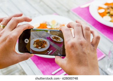 taking a picture of food on table - Shutterstock ID 628000748