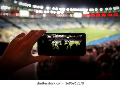 Taking Pictures On A Mobile Phone In A Sports Stadium. Focused On Fans