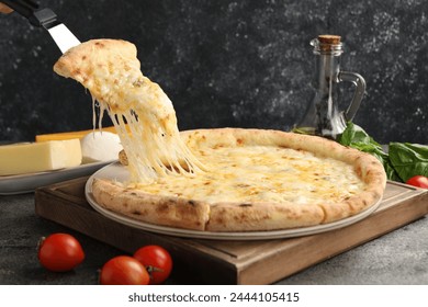 Taking piece of delicious cheese pizza at grey table - Powered by Shutterstock