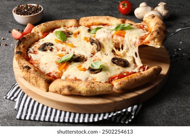 Taking piece of delicious vegetarian pizza at grey table, closeup - Powered by Shutterstock