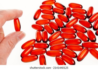 Taking A Pill. Hand Holding A Red Pill.