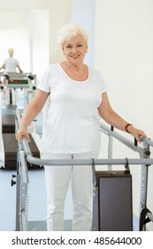 Taking Small Steps To Victory. Vertical Shot Of An Elderly Happy Woman Walking On A Treadmill During Physiotherapy