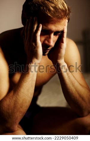 Taking strain. Stressed young guy with his head in his hands.