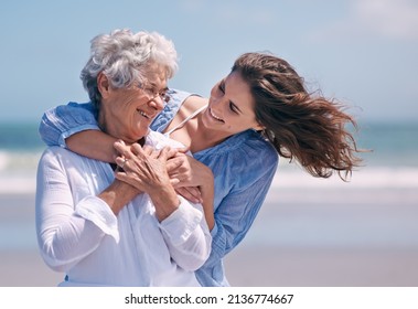 Taking time out to show some tenderness. Shot of a beautiful young woman and her senior mother on the beach. - Powered by Shutterstock