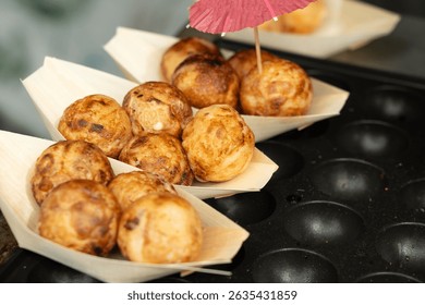 Takoyaki - traditional Japanese street food, outdoor snack with octopus Takoyaki fried balls, delicious squid dumplings