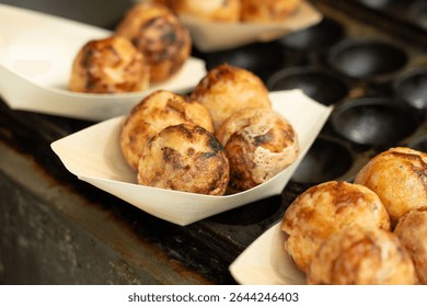 Takoyaki - traditional Japanese street food, outdoor snack with octopus Takoyaki fried balls, delicious squid dumplings