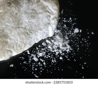 Talc sample being crushed into powder against a black background