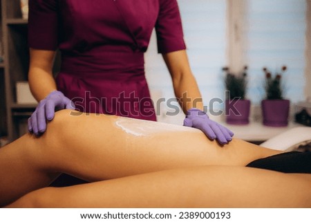 Talc from a white bottle is poured on the feet before the depilation procedure. The process of sugaring. 