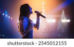 Talent Show Performance: Portrait of a Young Female Pop Singer on a Stage with Colorful Neon Lighting. Musician Singing a Powerful Solo, Poring Her Heartfelt Emotions into Beautiful Music