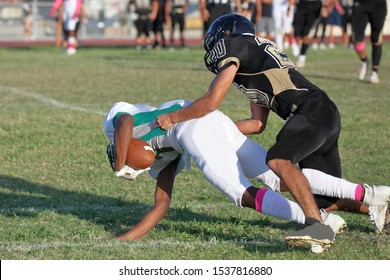 Talented Athletic Young Men Of High School Age Playing Tackle American Football On A Turf Field.