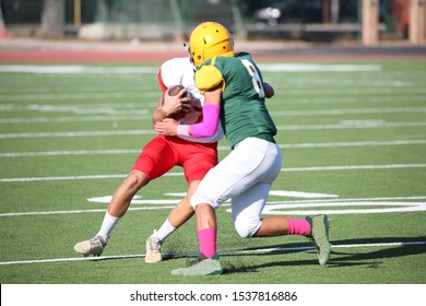 Talented Athletic Young Men Of High School Age Playing Tackle American Football On A Turf Field.