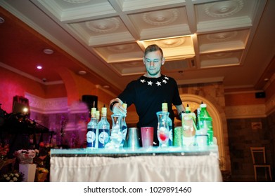 Talented Bartender Performing Tricks With Bottles And Glasses In Front Of Guests On Wedding Party.