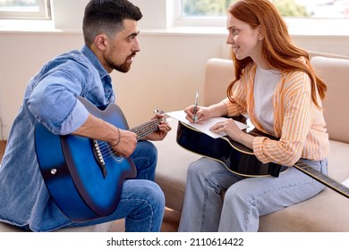 Talented and beautiful female male singers working together in bright studio with fun and happiness, caucasian man and woman discuss and consult about note and lyrics. Side view. Music concept - Powered by Shutterstock