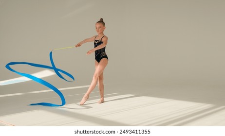 Talented Caucasian little girl child kid daughter gymnast dancer sport ballerina athlete perform acrobatic exercise spinning gymnastic ribbon artistic element in white studio dance class ballet school - Powered by Shutterstock