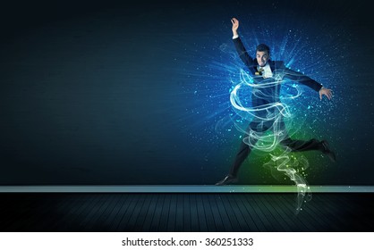 Talented cheerful businessman jumping with glowing energy lines on background
