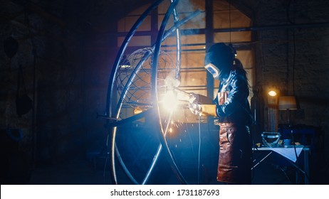 Talented Emerging Female Artist is Welding an Abstract, Brutal Metal Sculpture that Reflects the Present Moment. Beautiful Tomboy Fabricator in Checkered Shirt Creating Modern Steel Art. - Powered by Shutterstock