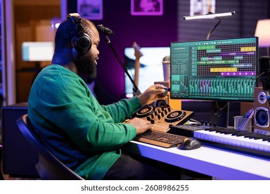 Talented engineer using an usb stick to edit recorded files in home studio, working on music post production. Young audio technician adding sound effects on mixing console and pc interface.