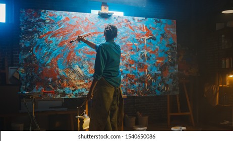 Talented Female Artist Works on Abstract Oil Painting, Using Paint Brush She Creates Modern Masterpiece. Dark and Messy Creative Studio where Large Canvas Stands on Easel Illuminated. - Powered by Shutterstock