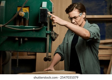 A talented female carpenter focuses on her task as she expertly operates a powerful saw in the workshop. - Powered by Shutterstock