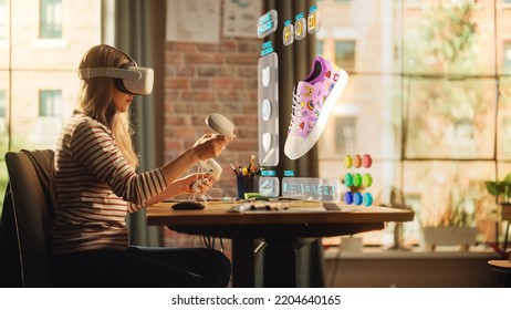 Talented Female Shoes Designer Wearing Virtual Reality Headset And Using Controllers To Design A Fashionable Sneaker In Augmented Reality Software. Woman Working On Custom Digital Footwear At Home.