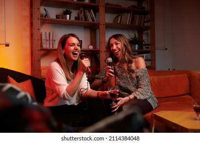 Talented girls with beautiful voices sit at home and sing a duet at karaoke night. - Powered by Shutterstock