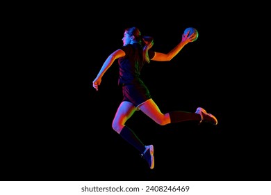 Talented handball player, female sportsman practicing techniques, capturing intensity of sport against black background in neon light. Concept of hobby, movement, dynamic, lifestyle, championship. Ad - Powered by Shutterstock