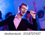 Talented Singer Guy On Karaoke Party Singing Song Having Fun In Night Club Indoor. Low Light