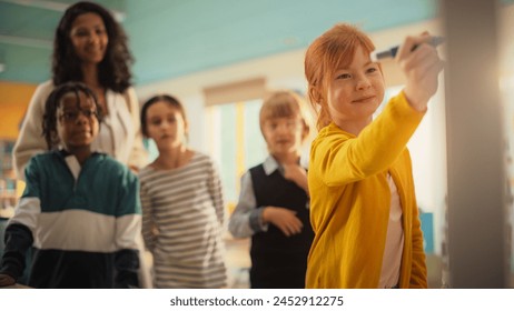 Talented Small Girl Solving an Arithmetic Equation that a Teacher Gave Her. Portrait of a Happy Elementary School Pupil Studying Hard, Writing a Correct Answer on a Whiteboard During a Math Class - Powered by Shutterstock