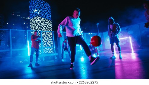 Talented Soccer Sportsman Performing Freestyle Tricks with a Ball. Footballer Showing Off Juggling Skills. Urban City Spot with Neon Lights, Graffiti on Walls and Scenery with Skyscrapers at Night - Powered by Shutterstock