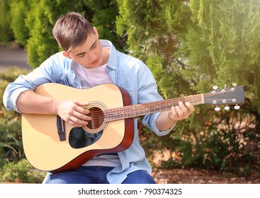 Talented Teenager Playing Acoustic Guitar In Park