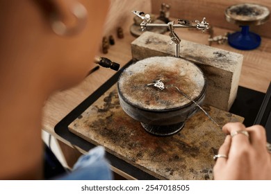 A talented woman delicately crafts intricate jewelry in her creative workspace filled with tools. - Powered by Shutterstock