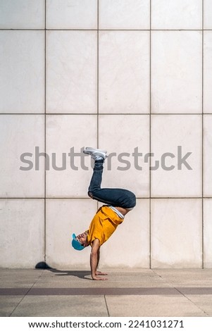 Similar – Man practicing yoga, handstand against a yellow wall