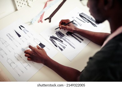 Talented young fashion design student drawing sketches of clothes for his fist collection - Powered by Shutterstock