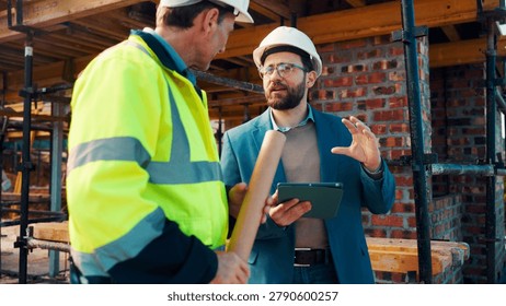 Talk, manager and architect with tablet for construction planning, building update and teamwork. Blueprint, architecture and men with tech outdoor for site regulations, code compliance and discussion