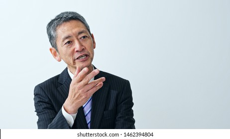 Talking Middle Aged Asian Businessman. Interview Concept.