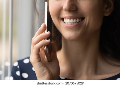 Talking on phone. Close up of smiling young lady having nice telephone conversation holding cell to ear. Cropped shot of unknown teen female or millennial woman speak on cellular listen to good friend
