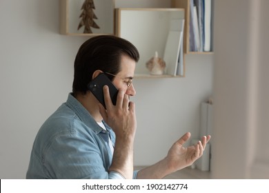 Talking On Phone. Confident Male Freelancer Holding Cellphone At His Ear Giving Professional Consultation To Customer From Home. Young Man Discuss Business With Friend Or Make Order Of Service Goods