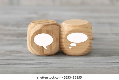Talking and thinking  concept. Two abstract geometric wooden dice isolate on white rustic surface. Antagonism concept.