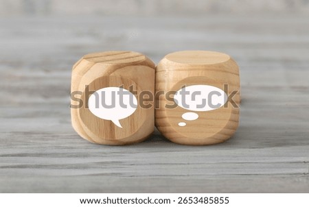 Talking and thinking  concept. Two abstract geometric wooden dice isolate on white rustic surface. Antagonism concept.