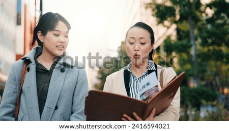 Talking, walking and Japanese women with a document in the city for business or teamwork on a project. Morning, smile and hr manager in Japan reading a report with an employee for recruitment
