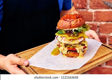 Tall, Big Burger On A Tray In Hands