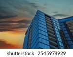 a tall blue glass skyscraper with balconies with blue sky and powerful clouds at sunset in Atlanta Georgia USA	