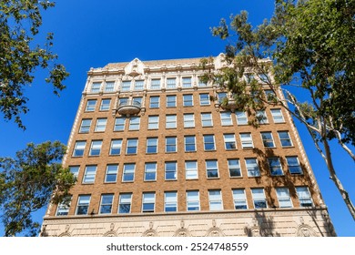 A tall brick building of Granada Theatre with ornate architectural details and decorative balconies is set against a bright blue sky - Powered by Shutterstock