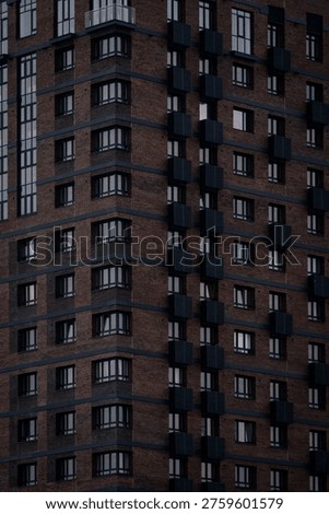 A tall brick high‑rise with repeating windows and dark horizontal accents in geometric patterns