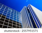A tall building with a blue sky in the background. The building is made of glass and has a modern design