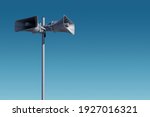 A tall column with two gray speakers against the sky. The system of general warning of the population about the danger. Possibility to post your test or image.