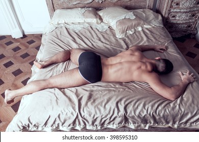 Tall Guy In Black Underpants Lies Full Body On Grand Bed Back To Camera