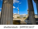 A tall house and behind it Berliner Fernsehturm – The Berlin TV Tower is located in Berlin