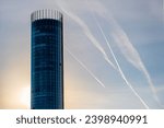 A tall house in the form of a round tower against the sky.